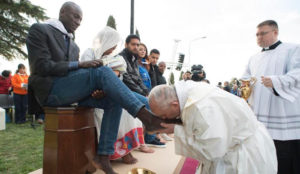 Pope Francis kisses the foot of a man during the foot-washing ritual at the Castelnuovo di Porto refugees center, some 30km (18, 6 miles) from Rome, Thursday, March 24, 2016. The pontiff washed and kissed the feet of Muslim, Orthodox, Hindu and Catholic refugees Thursday, declaring them children of the same God, in a gesture of welcome and brotherhood at a time when anti-Muslim and anti-immigrant sentiment has spiked following the Brussels attacks. (L'Osservatore Romano/Pool Photo via AP)